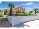 Traditional home featuring mature landscaping, palms and a stucco privacy wall at 8437 Apple Hill Ct, Las Vegas, NV 89128
