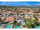 Expansive aerial view of a neighborhood featuring homes with pools and solar panels at 8713 Castle Ridge Ave, Las Vegas, NV 89129