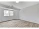 Bright bedroom featuring a large window with neighborhood views and wood-look flooring at 8713 Castle Ridge Ave, Las Vegas, NV 89129