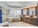 Elegant bathroom featuring double sinks, vanity, bathtub, glass enclosed shower, and tile flooring at 8713 Castle Ridge Ave, Las Vegas, NV 89129