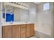 Well-lit bathroom features double sink vanity and bathtub with white tiled surround at 9303 Gilcrease Ave # 1056, Las Vegas, NV 89149