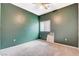 Empty bedroom with green accent wall, ceiling fan, and natural light from a window at 9303 Gilcrease Ave # 1056, Las Vegas, NV 89149