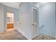 Hallway with neutral carpet leads to a bathroom with a wooden vanity and a bright light fixture at 9303 Gilcrease Ave # 1056, Las Vegas, NV 89149