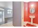 Stylish powder room with pedestal sink and red accent wall at 9303 Gilcrease Ave # 1056, Las Vegas, NV 89149