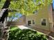 Backyard featuring artificial grass, a concrete patio, brick trim and mature trees at 9452 Plover Falls Ave, Las Vegas, NV 89149