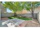 Inviting backyard featuring artificial turf, mature trees and a small bench at 9452 Plover Falls Ave, Las Vegas, NV 89149