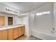 Bathroom featuring double sinks, a tub, and natural light from a window at 9452 Plover Falls Ave, Las Vegas, NV 89149