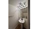 Cozy half-bathroom featuring a pedestal sink, tiled floors, and modern lighting fixtures for added convenience at 9452 Plover Falls Ave, Las Vegas, NV 89149
