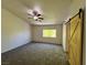 Large primary bedroom features carpet, ceiling fan, and a barn door leading to the attached bathroom for added privacy at 9452 Plover Falls Ave, Las Vegas, NV 89149