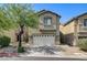 Inviting home featuring a two-car garage, drought-resistant landscaping, and a mature shade tree at 9452 Plover Falls Ave, Las Vegas, NV 89149