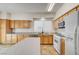 Charming kitchen offers white appliances, wood cabinets, and an island with countertop seating at 9452 Plover Falls Ave, Las Vegas, NV 89149