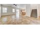 Spacious living room with tile flooring, natural light, and an open staircase at 9452 Plover Falls Ave, Las Vegas, NV 89149
