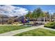 Community playground with slides and climbing area, surrounded by green grass at 9452 Plover Falls Ave, Las Vegas, NV 89149