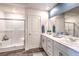 Elegant bathroom with double sinks, a white vanity, wood grain floors, and a glass-enclosed shower at 10400 Luna Mezzo St Ave # Lot 193, Las Vegas, NV 89141