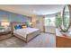 Bright bedroom featuring a decorative blue accent wall, woven bedframe, and large window with a view at 10400 Luna Mezzo St Ave # Lot 193, Las Vegas, NV 89141