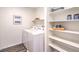 Convenient laundry room with washer, dryer, storage shelves, and contemporary decor at 10400 Luna Mezzo St Ave # Lot 193, Las Vegas, NV 89141