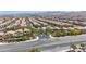 Overhead view of a community showcasing numerous homes and well-maintained streets against a mountain backdrop at 10692 Tulip Valley Rd, Las Vegas, NV 89179