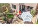 A cozy backyard patio space featuring patio furniture, a grill, a desert landscape, and a mature tree at 10692 Tulip Valley Rd, Las Vegas, NV 89179
