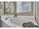 Bathroom with soaking tub, modern fixtures, and natural light from a window at 10692 Tulip Valley Rd, Las Vegas, NV 89179