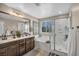 Bathroom with double vanity, soaking tub, and glass-enclosed shower at 10692 Tulip Valley Rd, Las Vegas, NV 89179