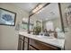 Bathroom featuring a double sink vanity with framed mirror, and a well-lit space at 10692 Tulip Valley Rd, Las Vegas, NV 89179