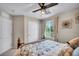 Inviting bedroom with ceiling fan, window with natural light, and cozy bed setting at 10692 Tulip Valley Rd, Las Vegas, NV 89179