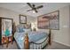 Comfortable bedroom with ornate metal bed frame, large windows, and ceiling fan at 10692 Tulip Valley Rd, Las Vegas, NV 89179
