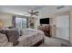 Relaxing bedroom featuring a comfortable bed, dresser with TV, and natural light from the window at 10692 Tulip Valley Rd, Las Vegas, NV 89179