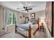Charming bedroom with a wrought iron bed frame, floral bedding, soft pillows, and a natural light-filled window at 10692 Tulip Valley Rd, Las Vegas, NV 89179