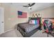 Inviting bedroom with dark furniture, an American flag, racing theme decor, and natural light from a large window at 10692 Tulip Valley Rd, Las Vegas, NV 89179