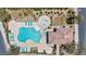 An aerial view of a community pool featuring lounge chairs, lush landscaping, and an adjacent covered patio at 10692 Tulip Valley Rd, Las Vegas, NV 89179