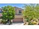 Inviting two-story home featuring a tile roof, desert landscaping, and a two-car garage at 10692 Tulip Valley Rd, Las Vegas, NV 89179