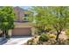 Inviting two-story home featuring a tile roof, desert landscaping, and a two-car garage at 10692 Tulip Valley Rd, Las Vegas, NV 89179