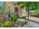 Charming front entrance, complete with an arched entryway, lush landscaping, and a spacious driveway for easy access at 10692 Tulip Valley Rd, Las Vegas, NV 89179