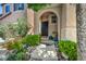Charming front entrance with manicured landscaping, mature trees, and a welcoming walkway to the front door at 10692 Tulip Valley Rd, Las Vegas, NV 89179