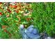 Beautiful garden with vibrant red flowers, lush green bushes, and a charming turtle statue at 10692 Tulip Valley Rd, Las Vegas, NV 89179