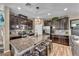 Spacious kitchen featuring granite countertops, an island with seating, stainless steel appliances, and dark cabinets at 10692 Tulip Valley Rd, Las Vegas, NV 89179