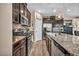 Well-equipped kitchen featuring stainless steel appliances, granite countertops, and dark cabinets with stylish backsplash at 10692 Tulip Valley Rd, Las Vegas, NV 89179