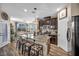 Spacious kitchen featuring granite countertops, an island with seating, stainless steel appliances, and dark cabinets at 10692 Tulip Valley Rd, Las Vegas, NV 89179