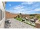 Backyard with pavers, seating area, green grass, and landscaped retaining wall at 10836 Montana Blanca Ave, Las Vegas, NV 89166