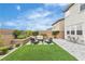 Inviting backyard featuring a seating area, green grass, and landscaped retaining wall at 10836 Montana Blanca Ave, Las Vegas, NV 89166