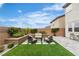 A backyard featuring an outdoor seating area, green grass, landscaping, and exterior of the home at 10836 Montana Blanca Ave, Las Vegas, NV 89166