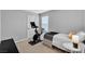 Bedroom with a sleek stationary bike near a bed with a patterned throw and a unique side table at 10836 Montana Blanca Ave, Las Vegas, NV 89166