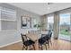 Dining room with sliding glass doors to backyard, wood floors, and modern lighting at 10836 Montana Blanca Ave, Las Vegas, NV 89166