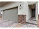Close up of home showcasing a two-car garage with stone accents and a paved walkway to the front door at 10836 Montana Blanca Ave, Las Vegas, NV 89166