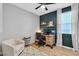 Home office featuring a rolling desk chair, accent wall, wood desk, and a bright window with white curtains at 10836 Montana Blanca Ave, Las Vegas, NV 89166