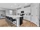 Modern kitchen with white cabinetry, a black island with bar seating, and stainless steel appliances at 10836 Montana Blanca Ave, Las Vegas, NV 89166