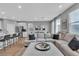 Spacious open-concept living room with a large sofa and open flow to dining and kitchen areas at 10836 Montana Blanca Ave, Las Vegas, NV 89166