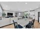 Open-concept living space with dining area, modern kitchen, and comfortable seating arrangement with light wood flooring at 10836 Montana Blanca Ave, Las Vegas, NV 89166