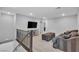 Upstairs loft area with gray sofa, ottoman, TV, and staircase with metal railing at 10836 Montana Blanca Ave, Las Vegas, NV 89166